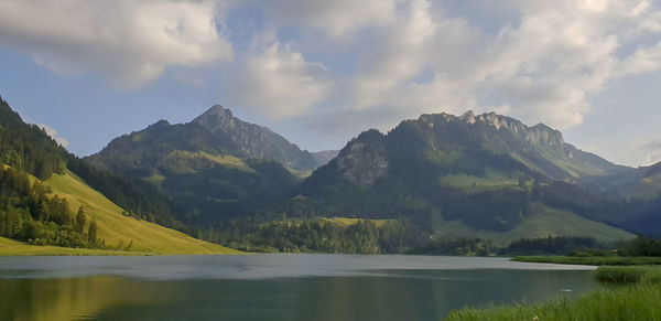 Scenic view of lake and mountains against sky