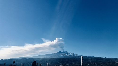 Scenic view of snowcapped mountains against blue sky