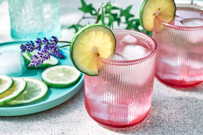 Cool lavender lemonade with lime slices and lavender flower on the table