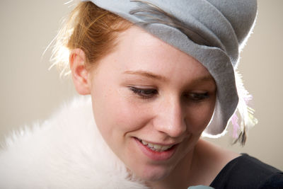 Close-up of young woman looking away against wall