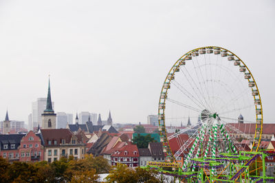 Ferris wheel in city against clear sky