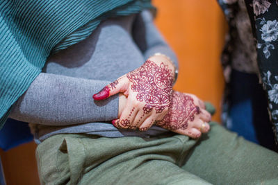 Midsection of woman with henna tattoo