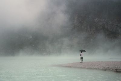 Man standing on wet road during rainy season