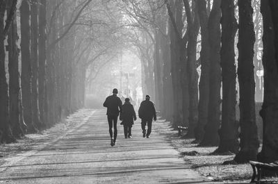 Rear view of silhouette people walking on snow covered landscape