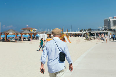 Rear view of people walking on beach