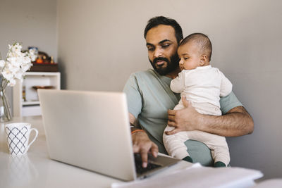 Father with baby working from home