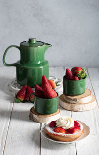 Fruit still life with strawberries and green tea set, strawberry cake with cream