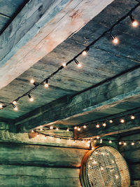 Low angle view of illuminated light bulbs hanging from ceiling
