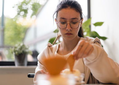 Portrait of a caucasian teenage girl with ice cream in a cafe.