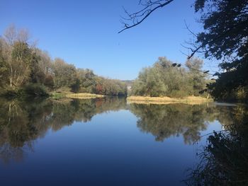 Scenic view of lake against clear blue sky