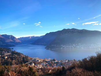 High angle view of townscape by mountains against blue sky