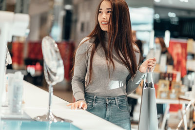 Portrait of smiling young woman standing in store