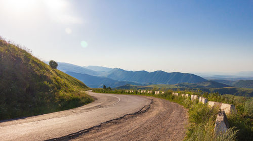 Road leading towards mountains against sky