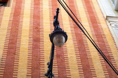 Low angle view of man hanging on building in city