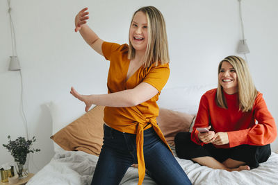 Happy sisters on bed