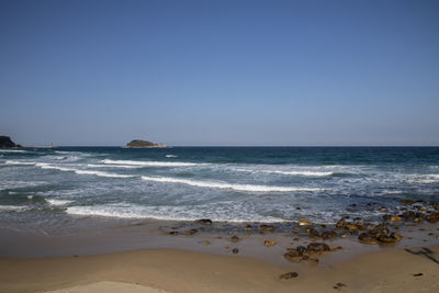 Scenic view of beach against clear sky