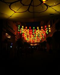 Illuminated lanterns hanging against sky at night