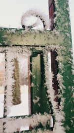 Old building seen through window during winter