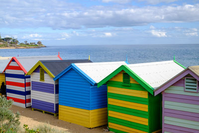 Beach huts on sea shore against sky