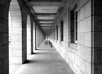 Rear view of man walking on corridor of building