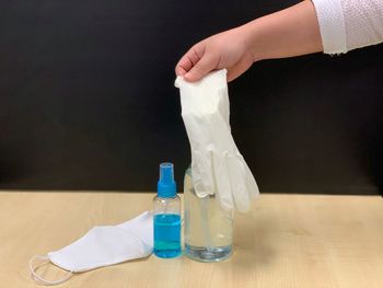 Close-up of hand holding glass bottle on table