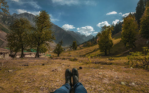 Low section of person on mountain against sky