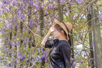 Woman standing in front of flowering plants