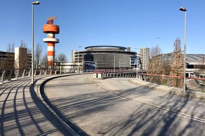 Road amidst buildings against clear sky