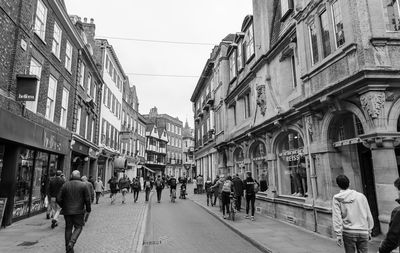 People walking on street amidst buildings in city