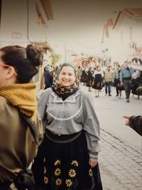 Portrait of smiling women standing in city during winter