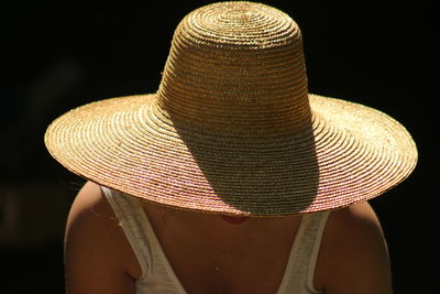 Rear view of person hat against black background