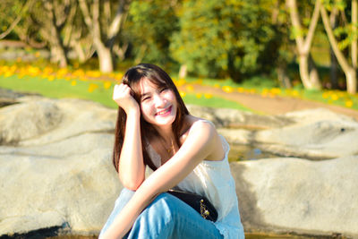 Young woman sitting on retaining wall