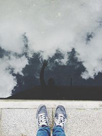 Reflection of man waving in pond