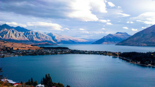 Scenic view of lake by mountains against sky