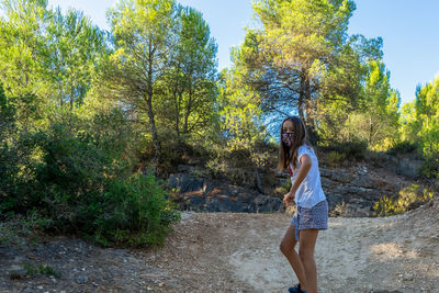 Portrait of girl wearing mask standing in forest