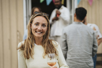 Portrait of smiling young woman with long hair during dinner party at cafe