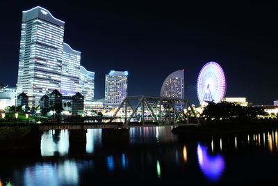 Illuminated ferris wheel in city at night