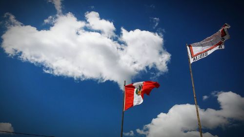 Low angle view of flag of peru against sky