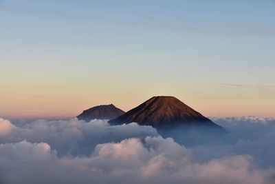 Scenic view of mountain against cloudy sky during sunset