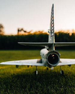 Close-up of model airplane on runway against sky