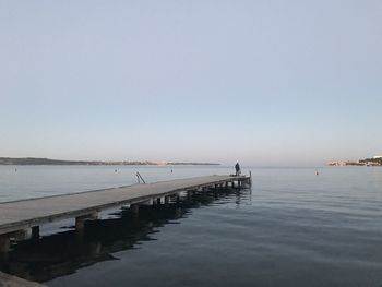 Pier over sea against clear sky