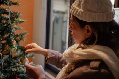 Christmas background - close up of woman decorating christmas tree