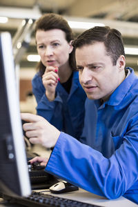 Technicians working on desktop pc together in industry