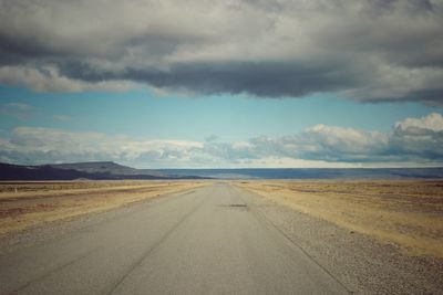 Empty road along countryside landscape