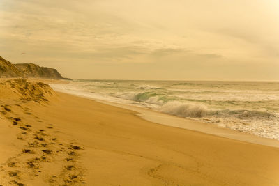 Scenic view of beach against sky during sunset