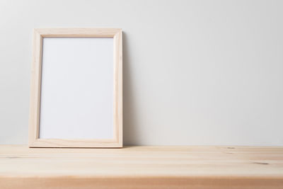 Close-up of white table against wall