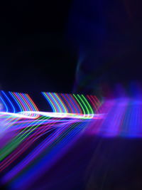 Illuminated light trails against black background