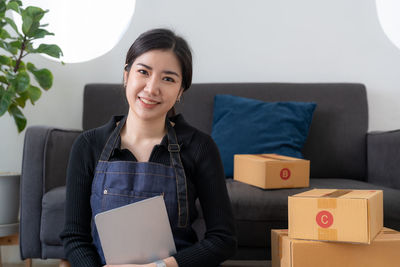 Portrait of young woman sitting on sofa at home