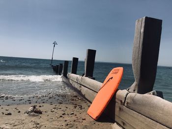 Wooden posts on beach against sky