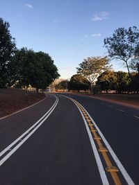 Road by trees against sky